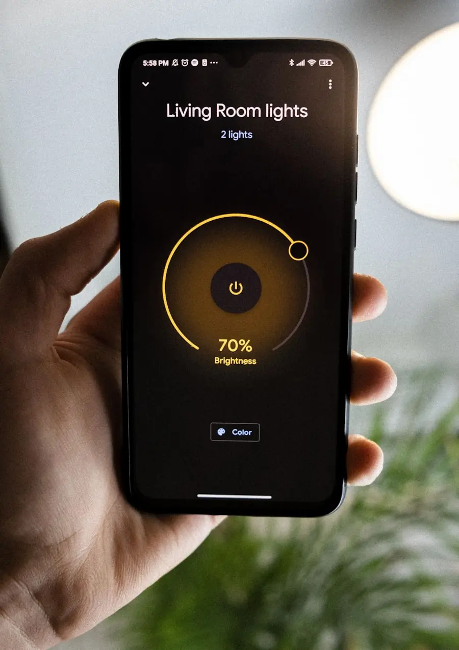 Hand holding a phone running a smart-home app dimming the living room lights