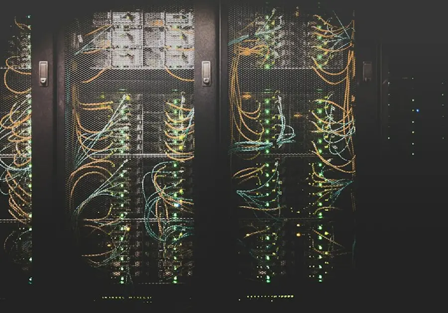 Server racks with patched network cabling and status lights in a dark data room
